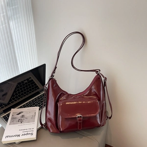 Sac hobo bordeaux brillant avec poche à boucle sur une scène de style de vie