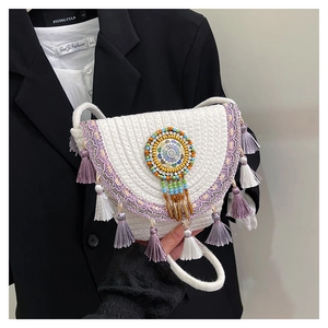 White woven bohemian crossbody bag with colorful tassels and hand-beaded disk detail