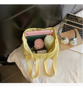 Top view of yellow canvas bucket bag showing large capacity with daily essentials inside