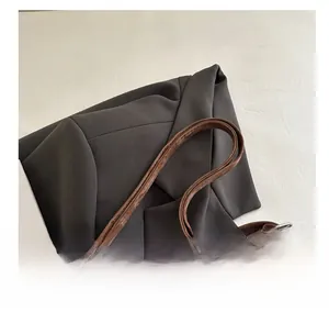 Detail eines braunen Lederriemens mit Metallschnallen und Reißverschluss an einer Tasche