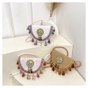 Detailed close-up of handmade woven straw bags with colorful tassels and beadwork