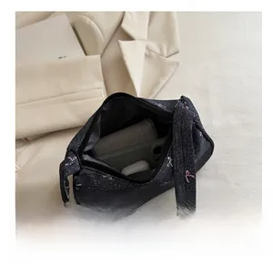Internal capacity of denim shoulder bag with bow prints showing daily essentials