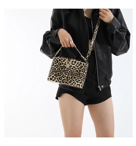 Detail of leopard print box bag with gold V clasp and adjustable wide strap