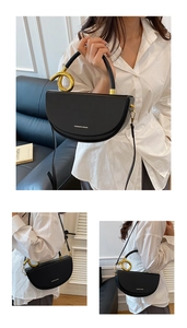 Details einer schwarzen Satteltasche mit goldenem Knoten-Griff und Markenlogo