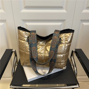 Golden quilted tote bag with wide tribal strap and spacious metallic fashion design