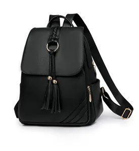 Detailed side view of black pebble leather backpack featuring tassels and gold hardware