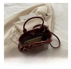Interior view showing capacity of burgundy patent leather crossbody bag with magnetic closure