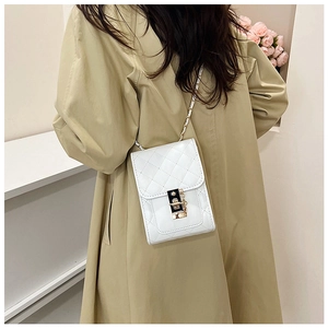 Detailed view of white quilted mini crossbody bag with gold-tone buckle on model