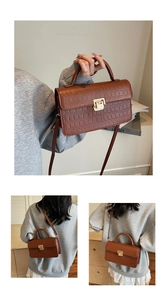 Detail of brown crocodile pattern handbag with gold clasp and sleek crossbody strap