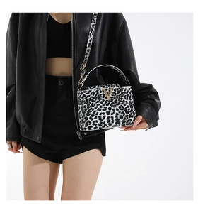 Close-up of leopard print handbag with golden metal V logo and stylish wide strap