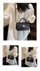 Detail of black faux leather handbag with crocodile pattern and gold twist lock closure