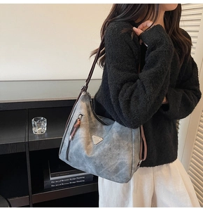 Detailed side view of vintage grey tote bag with contrast zipper pull on model
