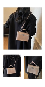 Dettaglio della piccola borsa quadrata in pelle beige con cerniera metallica