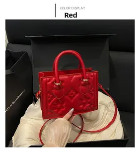 Detail of red embossed handbag with floral texture presented in a luxury gift box