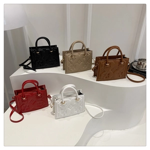 Detail view of five textured crossbody bags with floral embossing and gold hardware