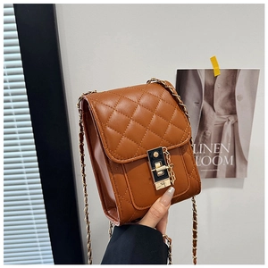 Detail of brown quilted PU leather crossbody bag with gold chain and metal lock