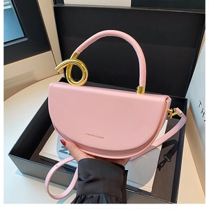 Detailaufnahme der rosa Leder-Satteltasche mit einzigartigem goldenem Metallgriff und Gurt