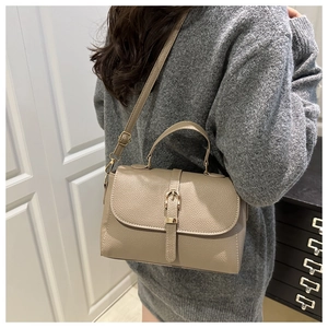 Detailed back view of a khaki textured leather handbag with a thin shoulder strap