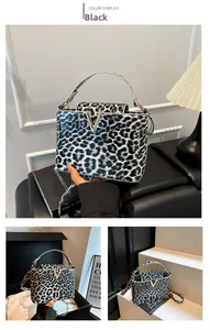 Detailed close-up of glossy leopard print handbag with V-shaped metal logo and top handle