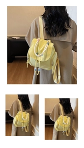 Detail of yellow nylon backpack with blue embroidery and colorful wooden bead drawstrings