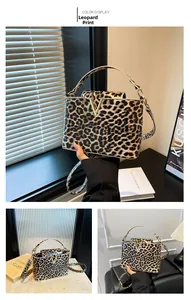 Detail of leopard print crossbody bag with gold V clasp and premium textured finish