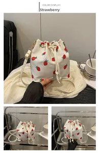 Detailed close-up of drawstring closure on white canvas bucket bag with strawberry prints