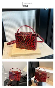 Detailed close-up of a red leopard print box bag featuring a metallic V-shaped buckle
