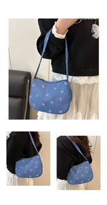 Detail of blue denim hobo bag featuring colorful embroidered bows and silver zipper