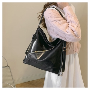 Macro detail of high-shine black oil wax leather surface with stylish slanted front zipper