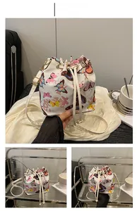 Detailed close-up of white bucket bag with colorful butterfly prints and drawstring
