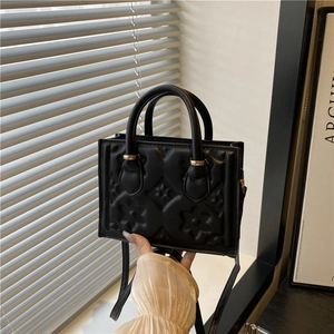 Chic black embossed crossbody bag with gold hardware and elegant top handle strap