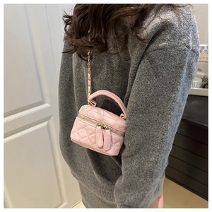 Dettaglio mini borsa in pelle PU rosa trapuntata con tracolla a catena dorata su modella