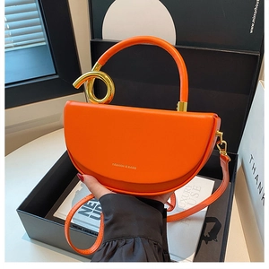 Orangefarbene Satteltasche aus Leder mit goldenem Drehgriff und modischem Logo-Detail