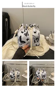 Detail of drawstring bucket bag with black butterfly print and metallic hook