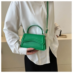 Fashionable bright green faux leather crossbody bag with wave stitching on the front flap