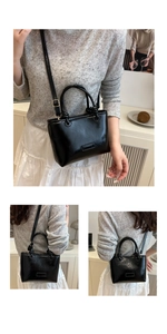 Detail of minimalist black patent leather square bag with knot handle and adjustable strap