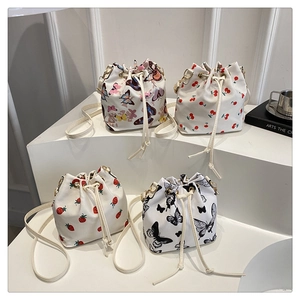 Collection of four stylish drawstring bucket bags with fruit and butterfly prints