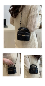 Three-way view of black quilted vanity case bag with gold chain strap and top handle