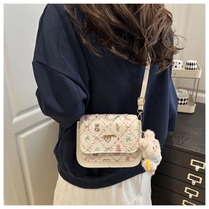 Detail of off-white crossbody bag with floral bear prints and plush rabbit charm