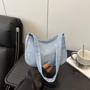 Light blue denim underarm bag featuring colorful mini bow embroidery and top handle