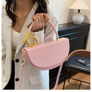 Detailaufnahme der rosa Satteltasche mit dekorativer goldener Schnalle und Gurt