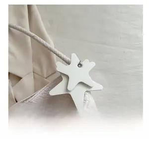 Detailed macro view of cream woven texture bag featuring stylish leather star charm decoration