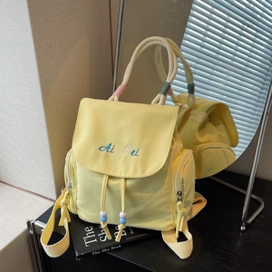 Pale yellow minimalist backpack with blue letter embroidery and bead drawstrings
