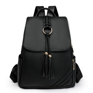 Women's black pebbled leather backpack with woven tassel and golden hardware details