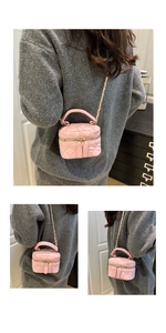Detailed side view of pink quilted mini chain bag worn as cross-body style on model