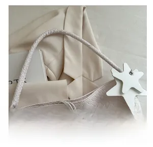 Detailed cream woven tote bag with star charms and inner drawstring pouch detail