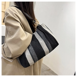Detail of woven striped canvas fabric texture and black leather strap with gold rings