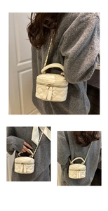 Close-up of white quilted mini chain bag showing detailed leather texture and gold hardware