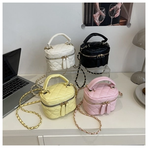 Detail of four quilted mini bags in white, black, yellow and pink with gold chain straps