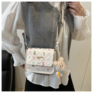 Détail du mini sac blanc à imprimé ours avec un porte-clés lapin en peluche